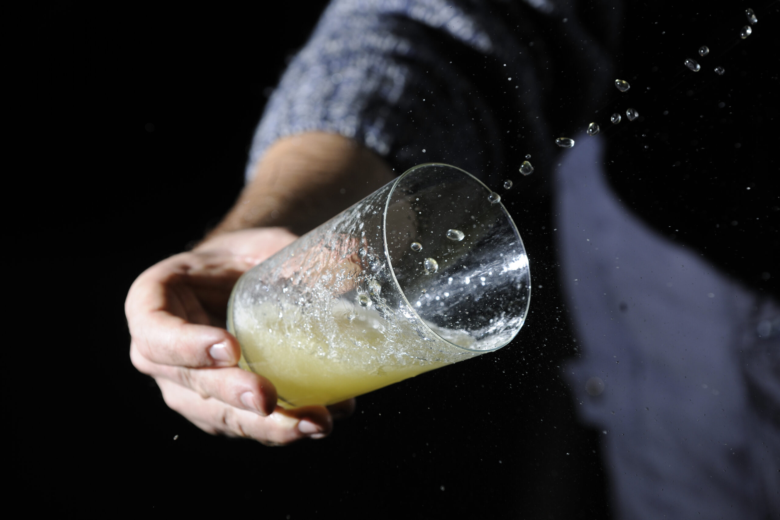 Verre recevant le jet de cidre tiré au tonneau lors du txotx dans une cidrerie basque